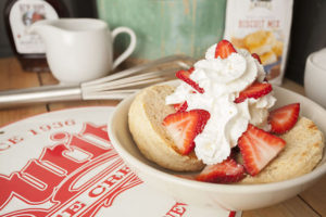 Photo of a bowl of strawberry shortcake with whipped cream