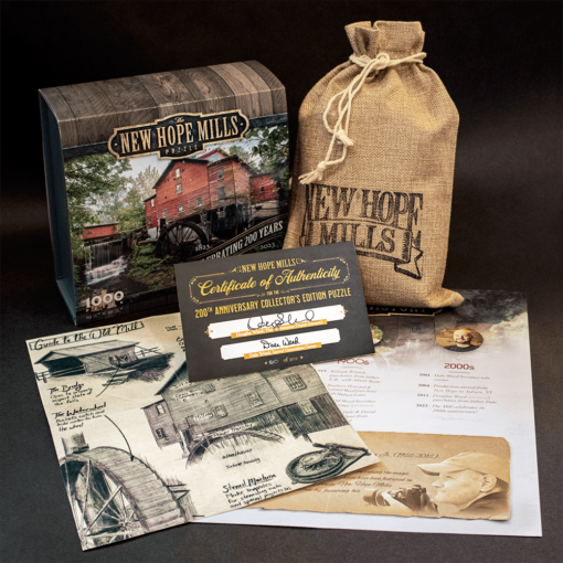 Photo of New Hope Mills Jigsaw Puzzle: Collector's Edition, with contents displayed (including canvas pouch for pieces, Certificate of Authenticity, and printouts with historical information in imagery.